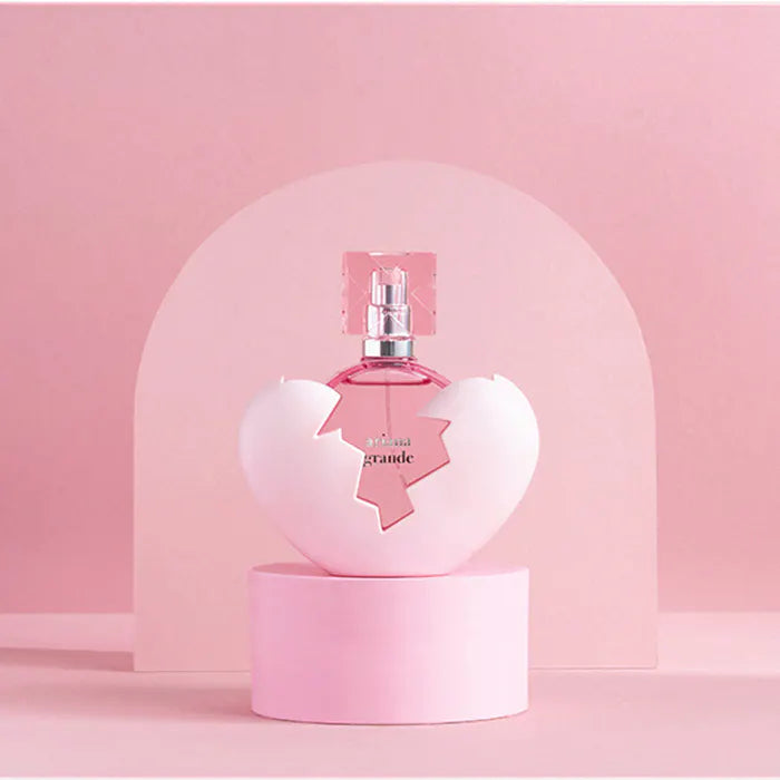 Pink perfume bottle in a decorative display with a pink background