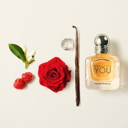 Perfume bottle labeled 'Because It's You' with a red rose, vanilla bean, and raspberry on a light background