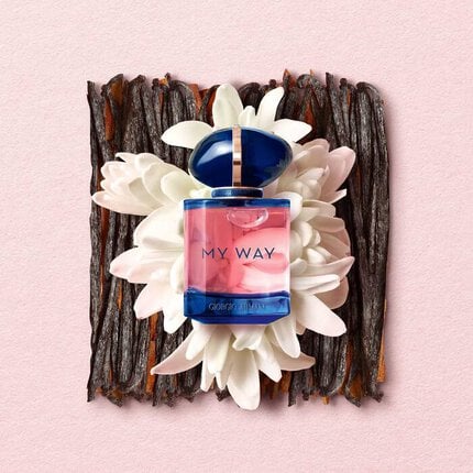 Perfume bottle labeled 'My Way' on a decorative background with flowers and wood.