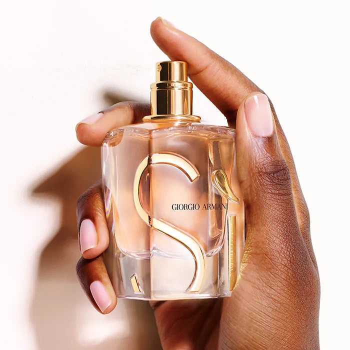 Hand holding a Giorgio perfume bottle with a blurred background