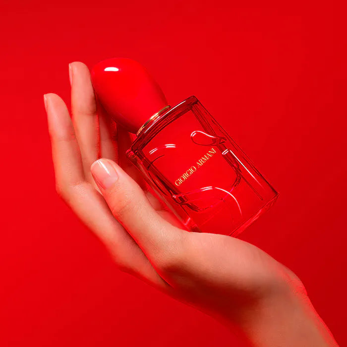 Red Giorgio nail polish bottle held in a hand against a red background