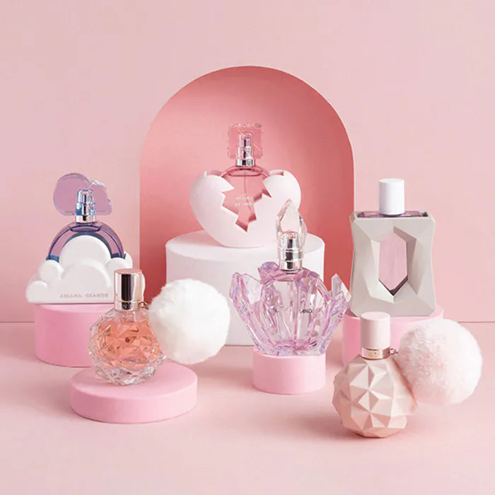 Collection of decorative perfume bottles on a pink background