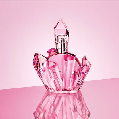 Pink perfume bottle with geometric design on a pink background