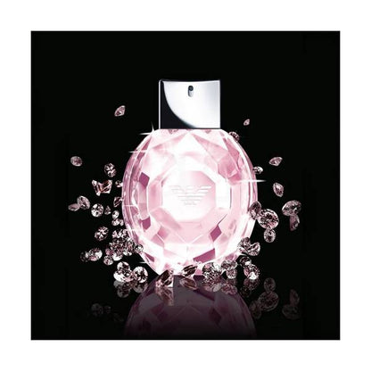 Pink diamond-shaped perfume bottle with scattered diamonds on a black background