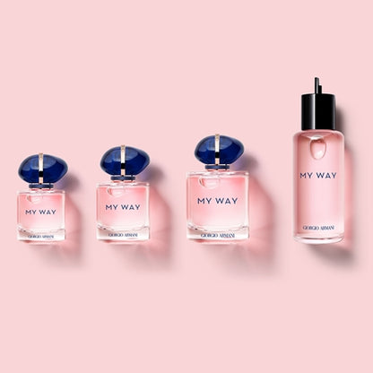 Four bottles of Giorgio 'My Way' perfume on a pink background