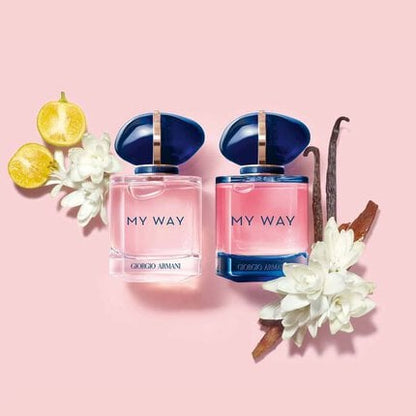 Two 'My Way' perfume bottles by Giorgio Armani on a pink background with floral and vanilla elements.