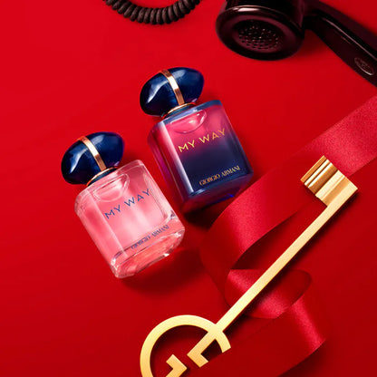 Two Giorgio  'My Way' perfume bottles on a red background with a key and phone.