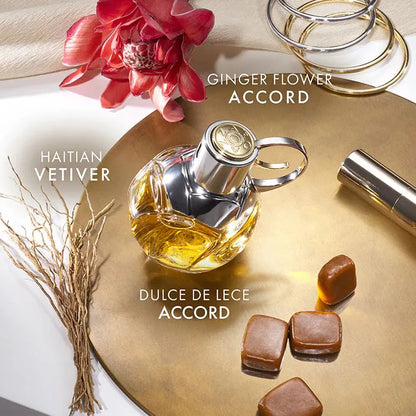 Perfume bottle with ginger flower and Haitian vetiver notes on a decorative surface.