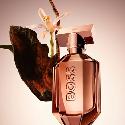 Rose gold BOSS perfume bottle with a flower on a beige background