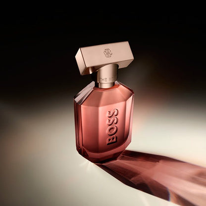 BOSS perfume bottle on a reflective surface with a dark background