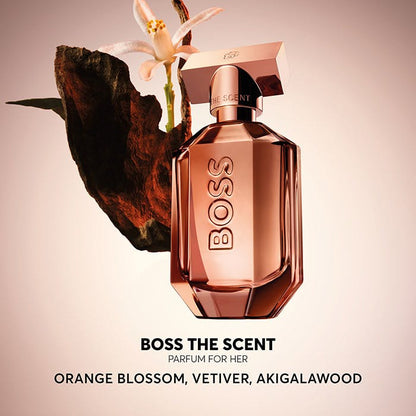 BOSS The Scent perfume bottle with floral elements on a beige background