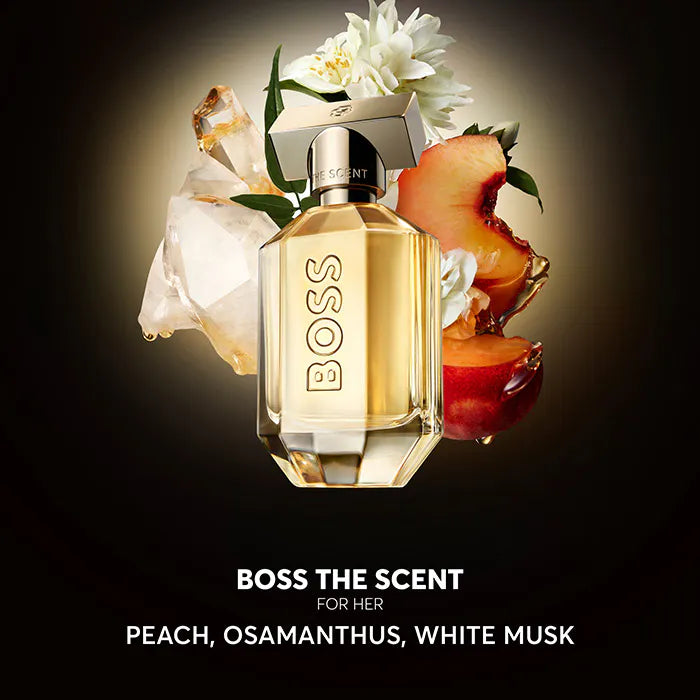 BOSS The Scent for Her perfume bottle with flowers on a dark background